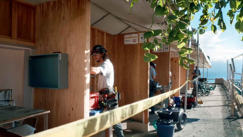 Worker performing electrical work at an outdoor competition booth