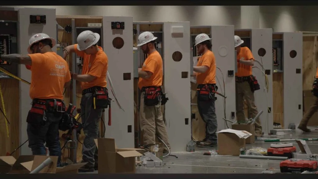 Electrical apprentices wiring panels during a training competition