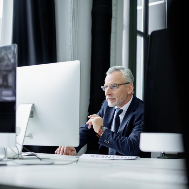 Businessman in a suit working at a desktop computer