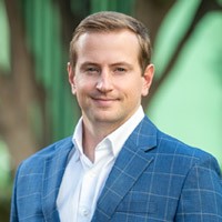 Professional headshot of a man in a blue blazer