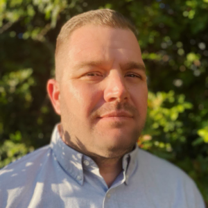 Professional headshot of a man in a light blue shirt