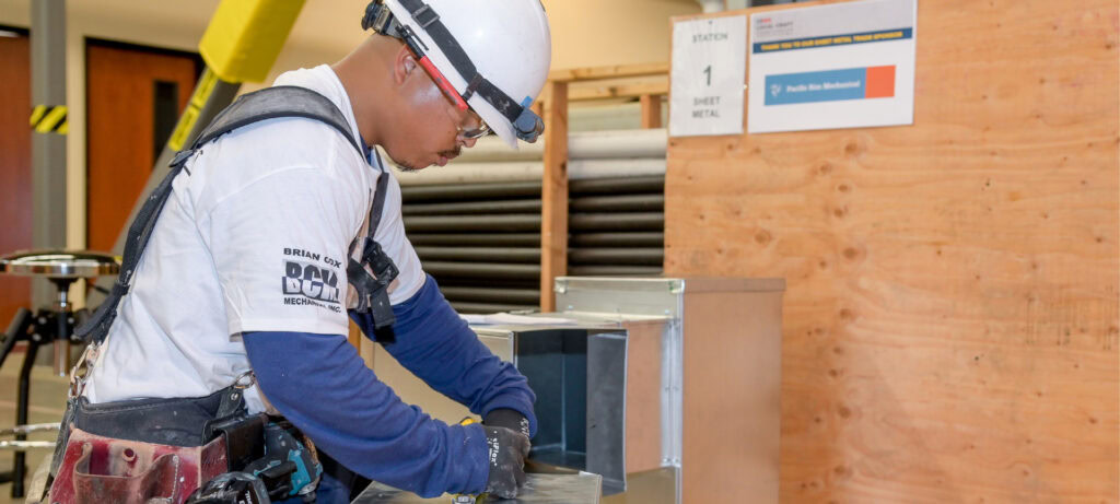 Sheet metal worker fabricating ductwork at a competition station