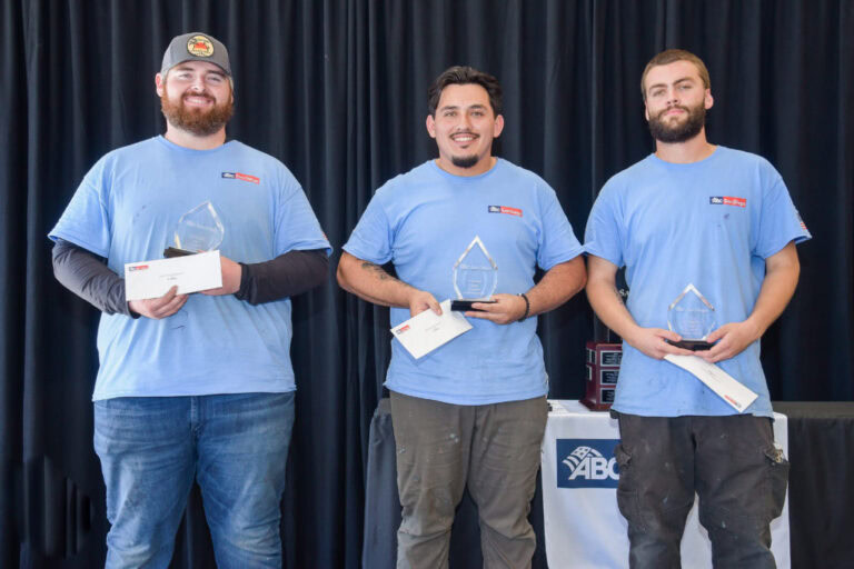 Three award winners holding trophies at a ceremony