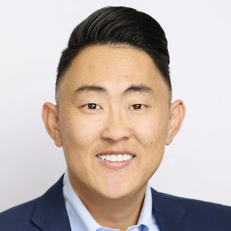 Professional headshot of a man in a blue suit