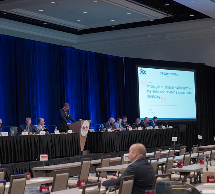 Speaker at a podium addressing a seated audience at an ABC conference