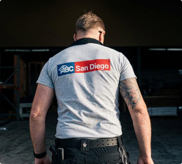 Man seen from behind wearing an ABC San Diego shirt at a job site