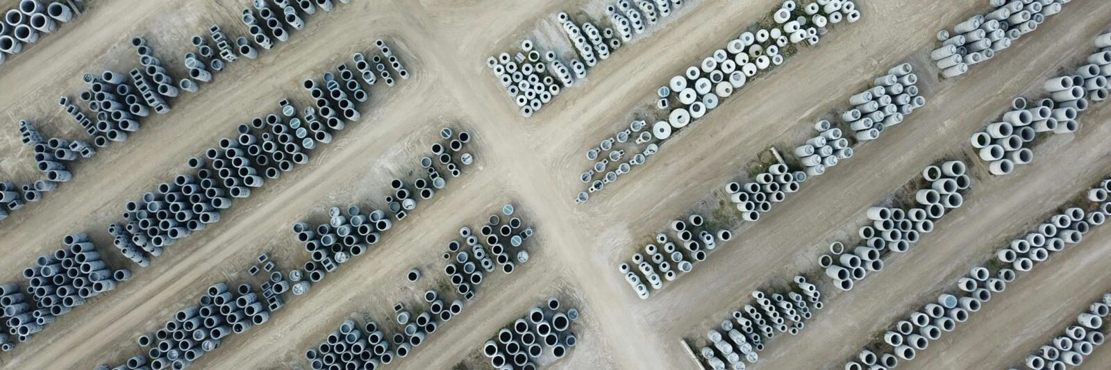 Aerial view of concrete pipes stacked in rows at a storage yard