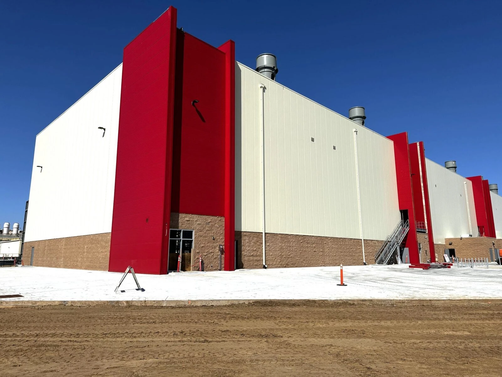 Red and white industrial building exterior under construction