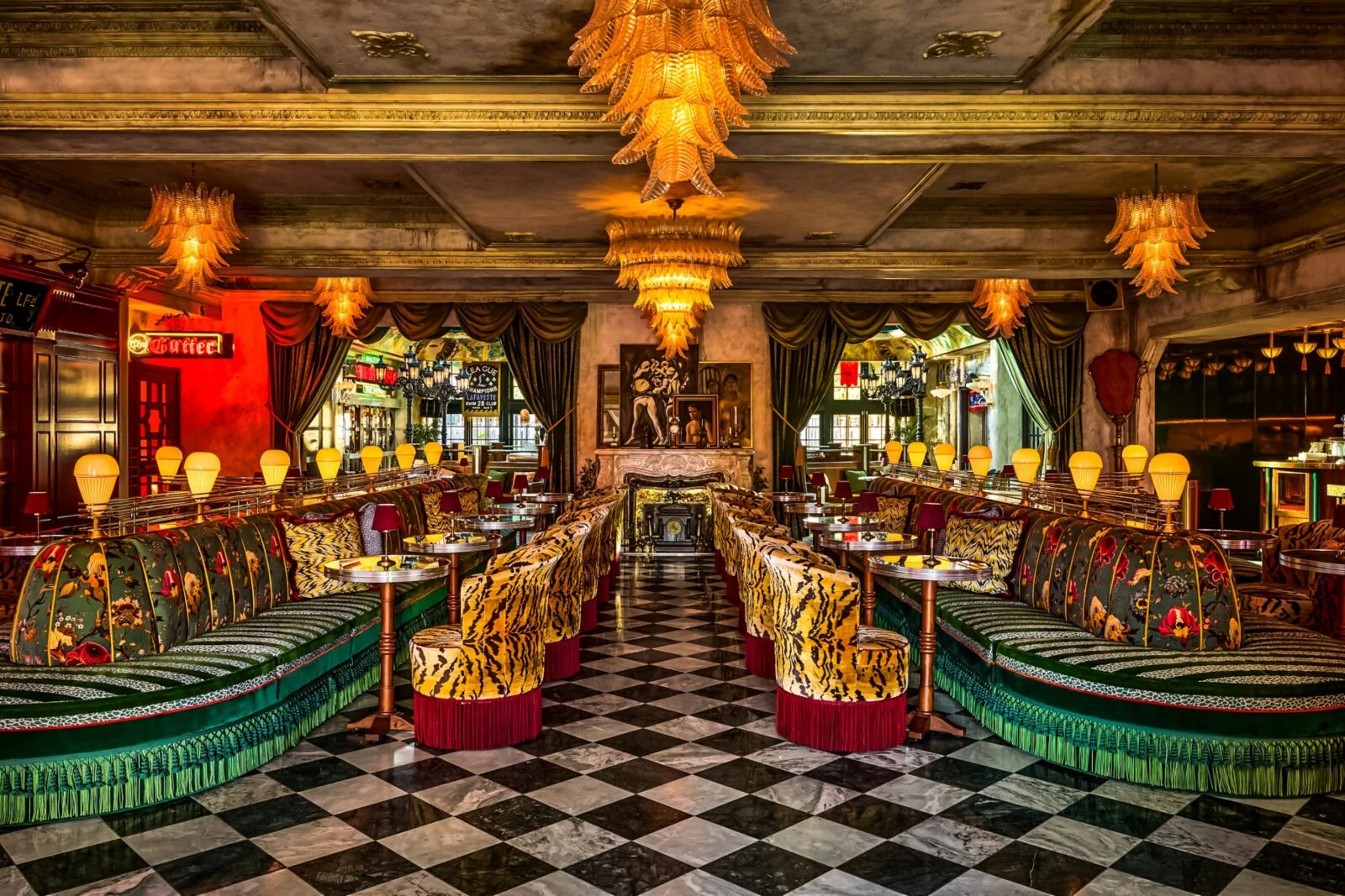 Elegant restaurant interior with vintage decor, patterned sofas, and checkered floor.