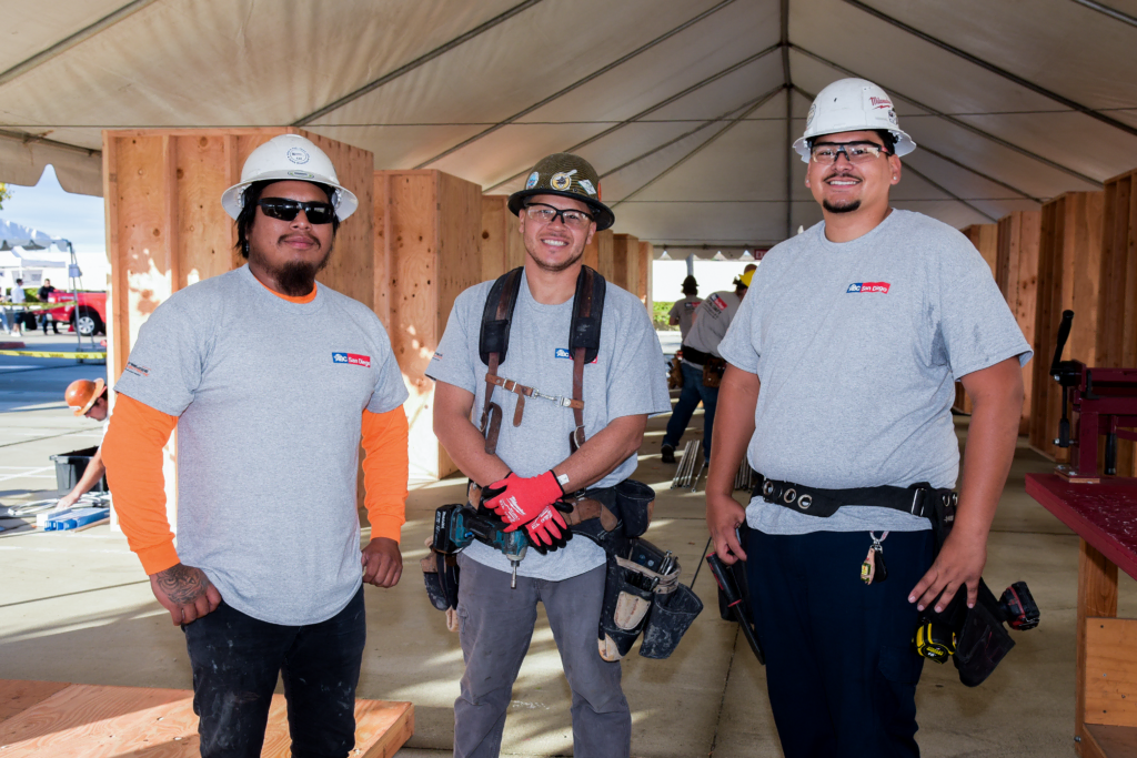 Three construction workers in safety gear at the Local Craft Championship event.
