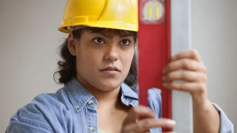 Young woman construction worker using a level tool.